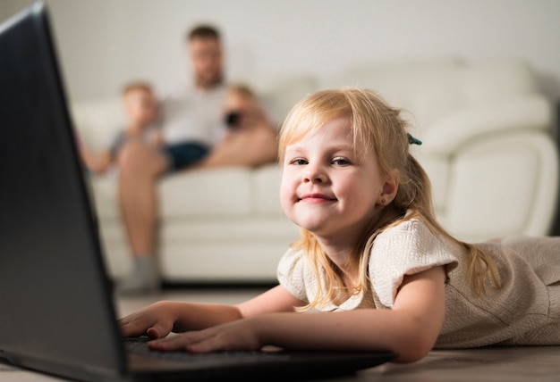 Niña rubia jugando en una computadora portátil