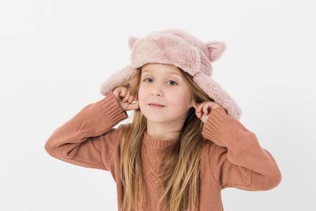 Niña rubia jugando con sus oídos