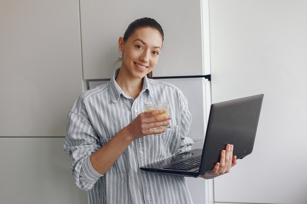 Niña sentada en casa y usar la computadora portátil