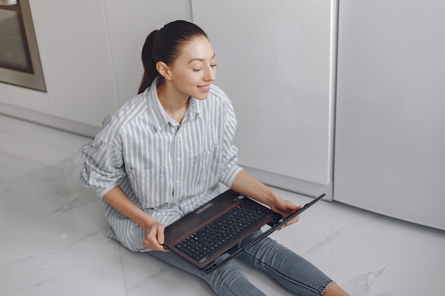 Niña sentada en casa y usar la computadora portátil