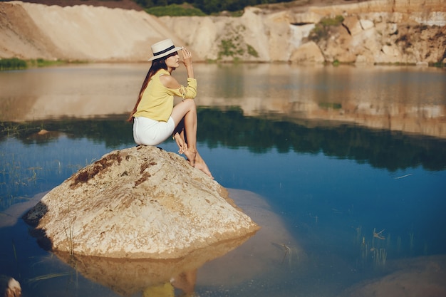 Foto gratuita niña sentada cerca del río