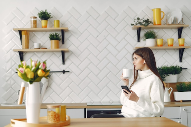 Niña sentada en una cocina y tomando un café