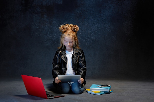 Niña sentada con gadgets