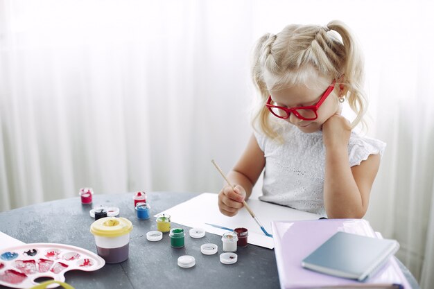 Niña sentada en una mesa y dibujo