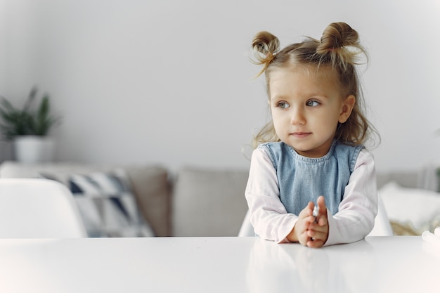 Niña sentada en una mesa con juguete