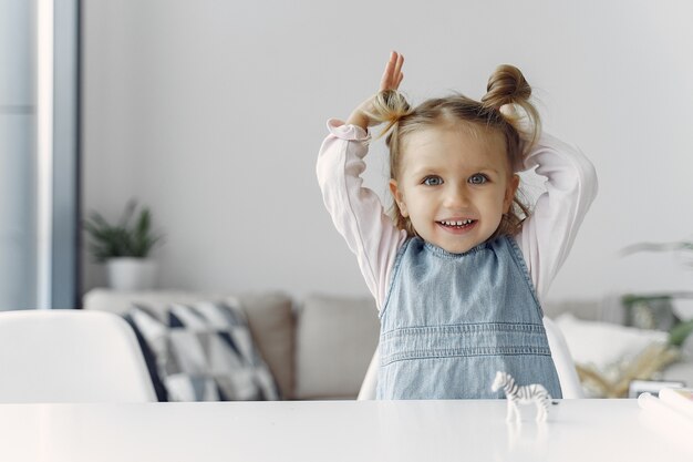 Niña sentada en una mesa con juguete