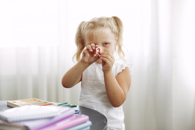 Niña sentada en una mesa con libros