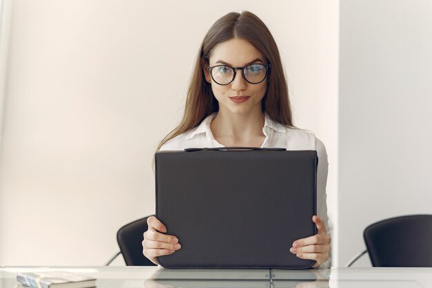 Niña sentada en la oficina con una computadora portátil