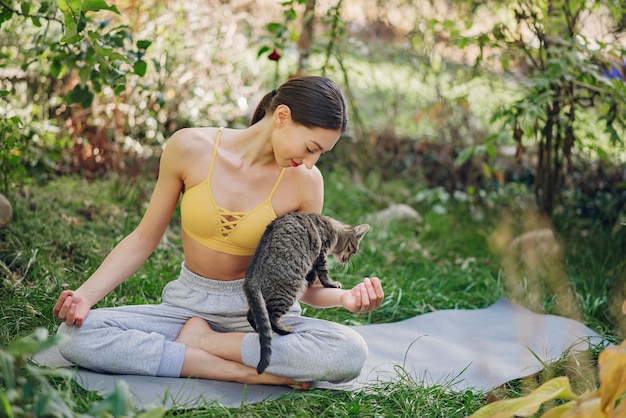 Niña sentada en un parque de verano con lindo gato