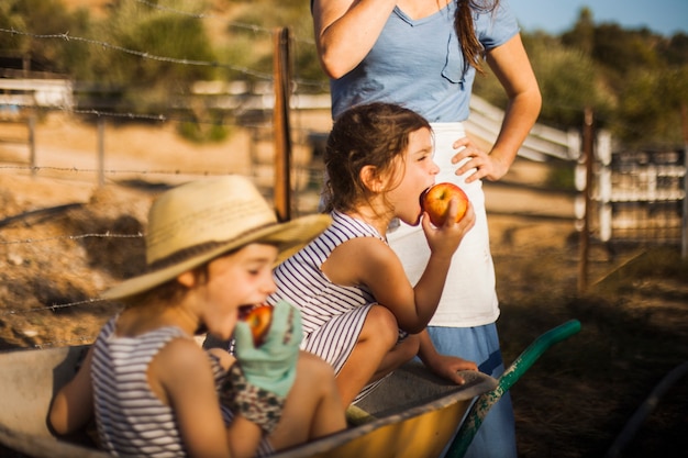 Niña sentada en la rueda prestada comiendo manzana