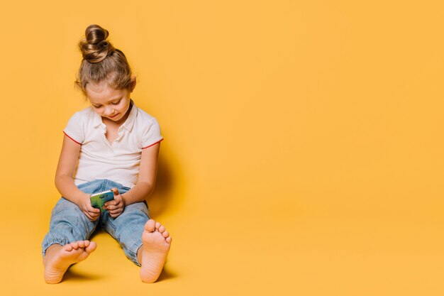 Niña sentada con smartphone