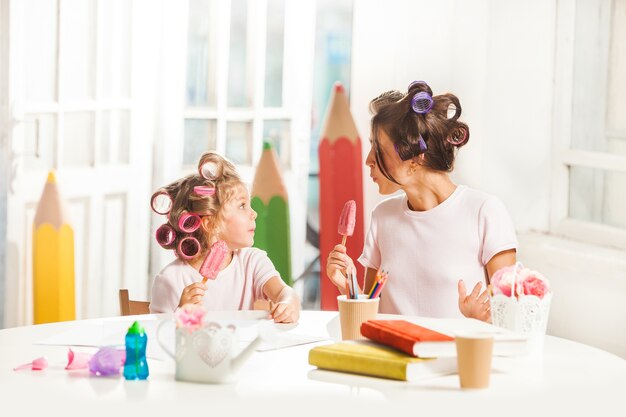 Niña sentada con su madre y comiendo helado