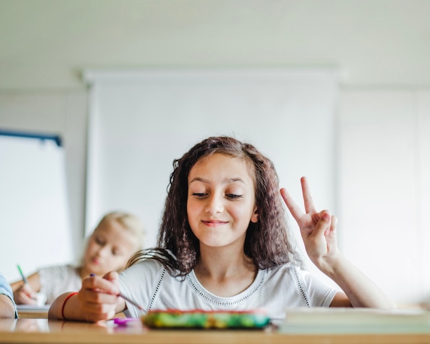 Niña, sentado, escuela, escritorio, gesticular