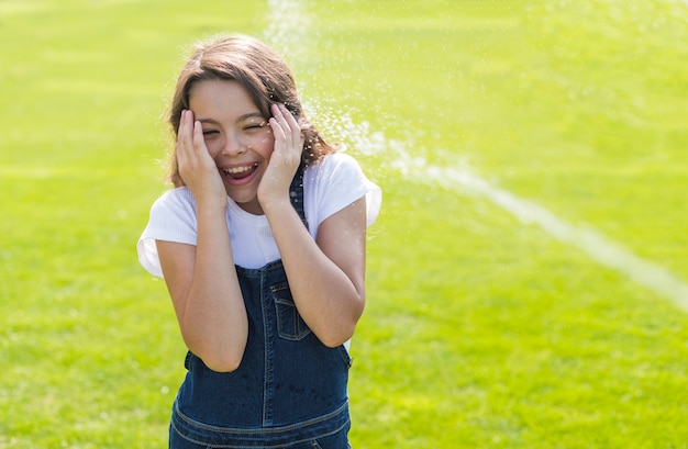 Foto gratuita niña siendo regada con una pistola de agua