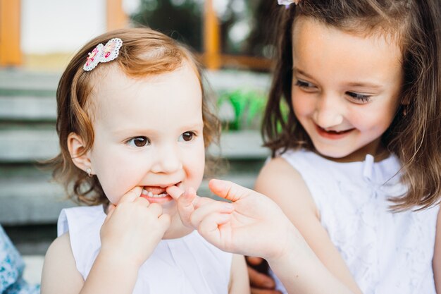 La niña se sienta con su hermana en pasos