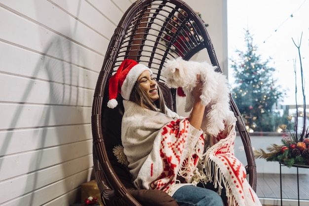 Niña en una silla capullo jugando con su mascota en la víspera de año nuevo