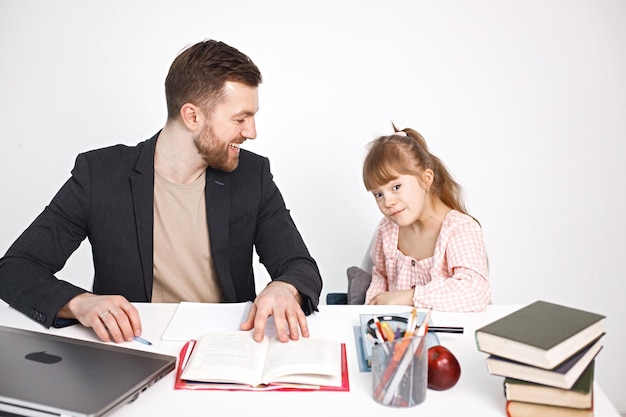 Foto gratuita niña con síndrome de down estudiando con su maestra en casa