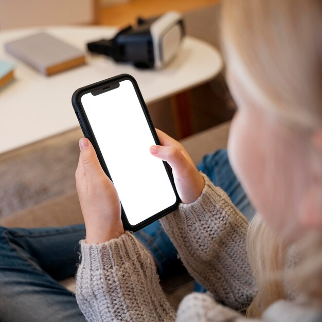 Niña con smartphone en casa