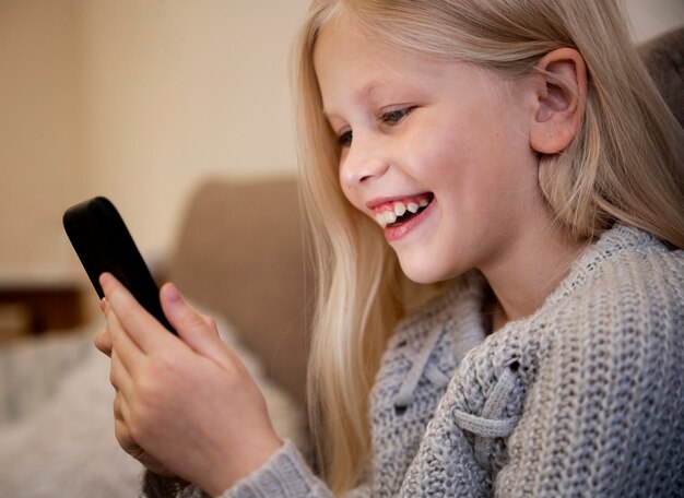 Niña con smartphone en casa