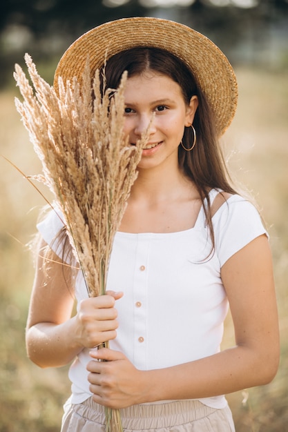Foto gratuita niña con sombrero en un campo de trigo