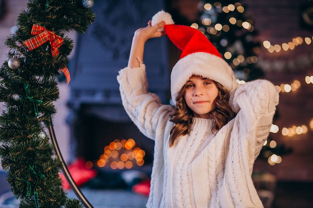 Niña en un sombrero de santa en Navidad