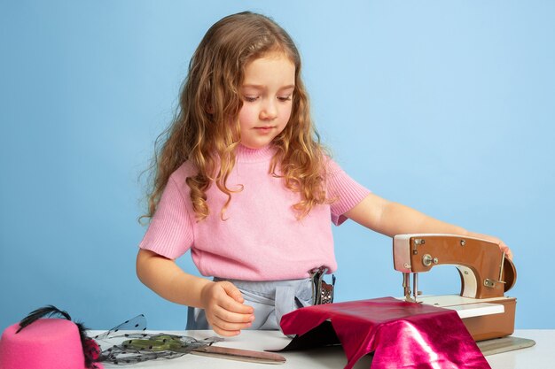 Niña soñando con la futura profesión de costurera