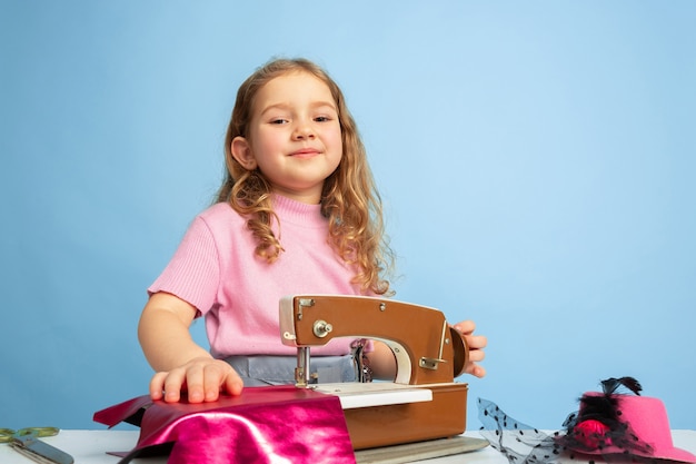 Niña soñando con la futura profesión de costurera