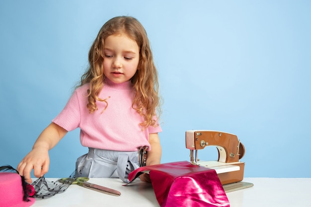 Niña soñando con la futura profesión de costurera