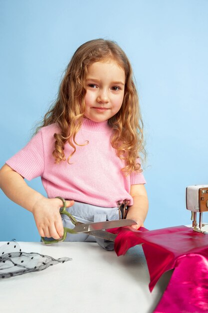 Niña soñando con la futura profesión de costurera