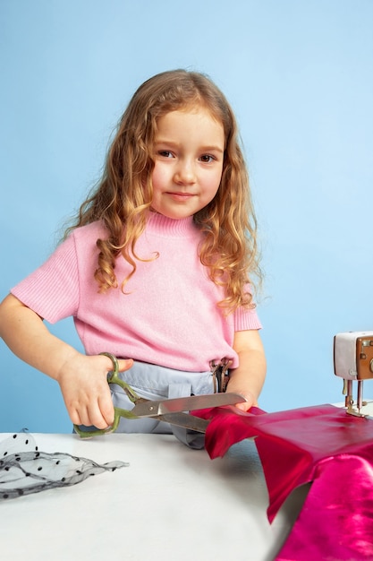 Niña soñando con la futura profesión de costurera