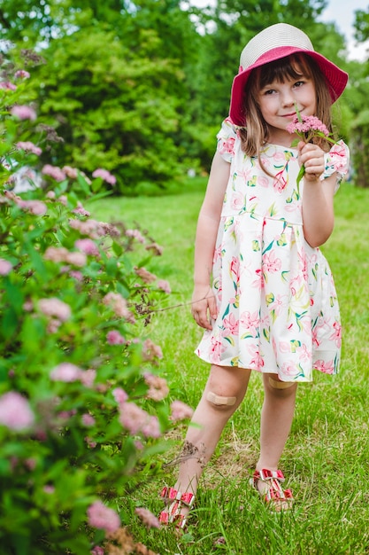 Niña sonriendo con flores en una mano