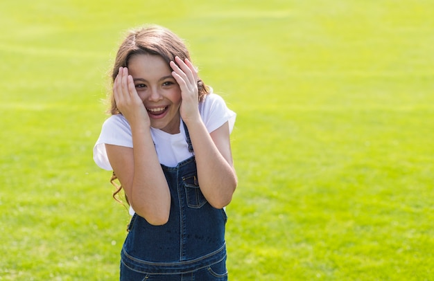 Niña sonriendo y jugando afuera