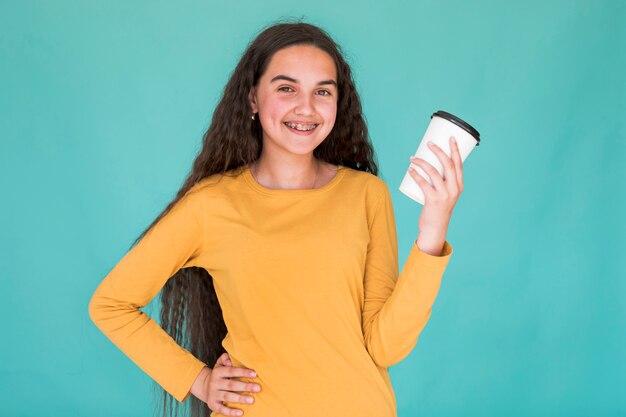 Niña sonriendo mientras sostiene su bebida