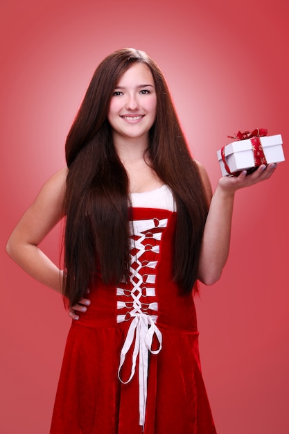 Niña sonriendo con un regalo de Navidad