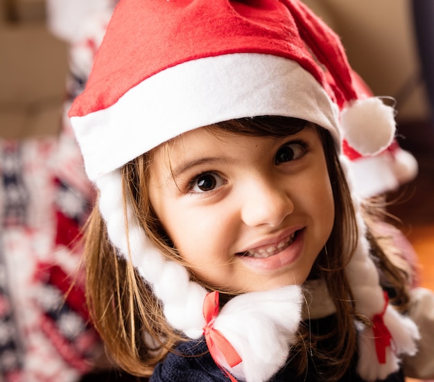 Niña sonriendo con el sombrero de papa noel