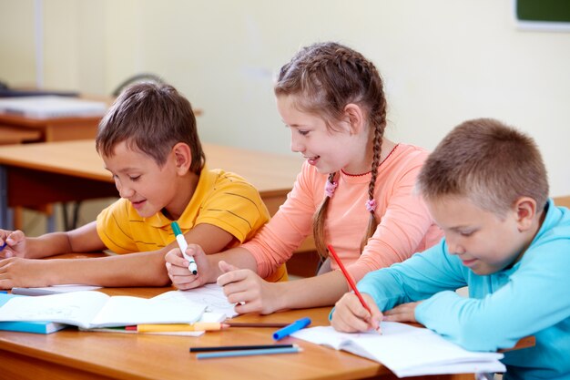 Niña sonriendo con sus compañeros de clase