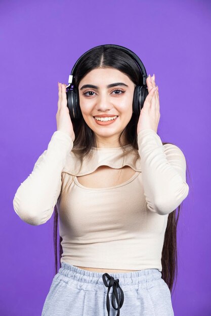 Niña sonriente con auriculares y mirando a la cámara Foto de alta calidad