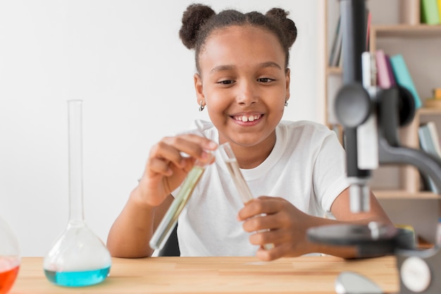 Niña sonriente con bañera de prueba con poción