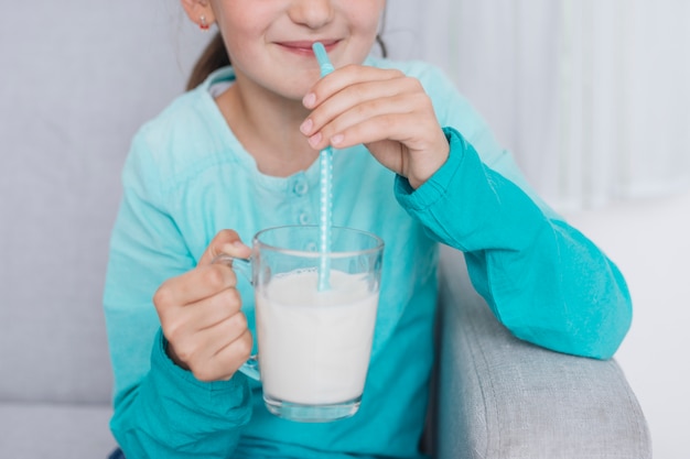 Niña sonriente bebiendo leche