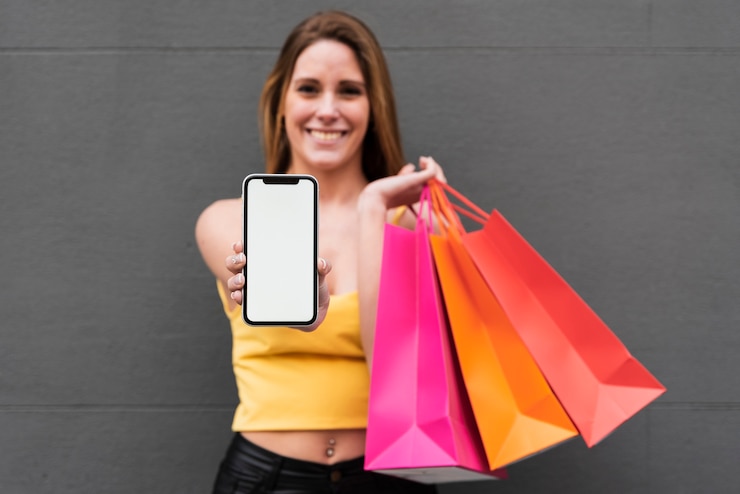 Foto gratuito niña sonriente con bolsas de compras con teléfono