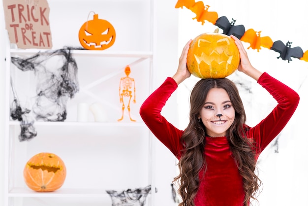 Niña sonriente con calabaza tallada