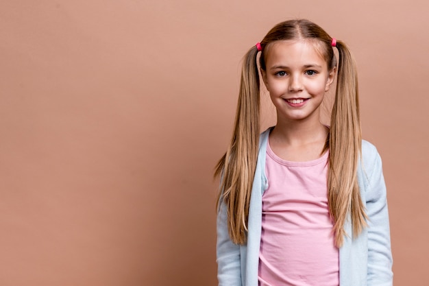 Niña sonriente con colas de polietileno y espacio de copia