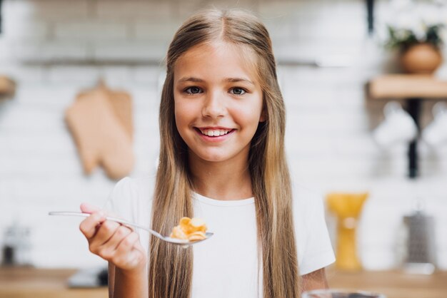 Niña sonriente comiendo sus cereales