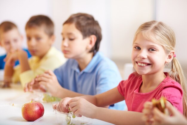 Niña sonriente comiendo uvas