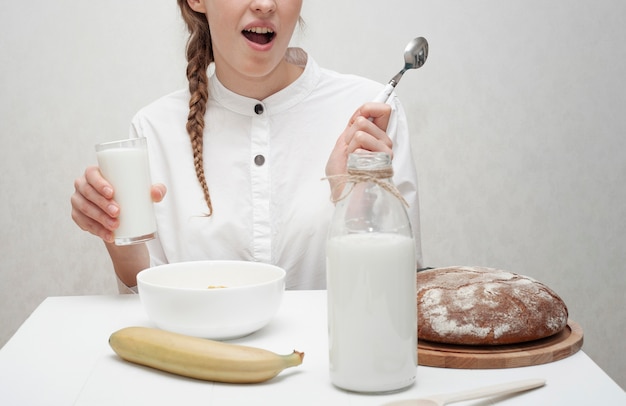 Niña sonriente desayunando con fondo blanco