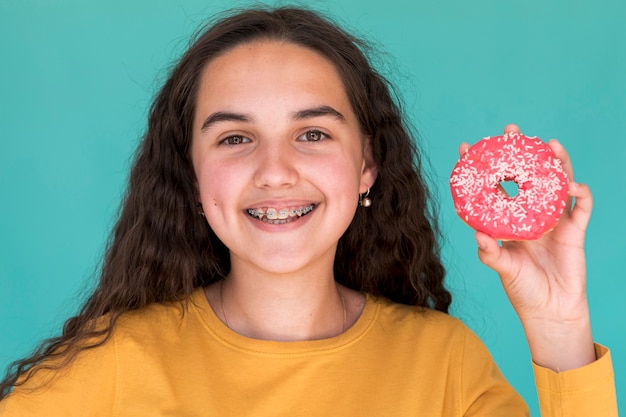 Foto gratuita niña sonriente con donut glaseado