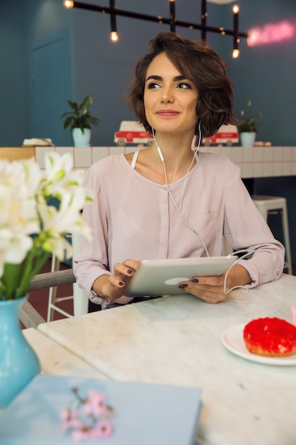 Niña sonriente escuchando música con auriculares