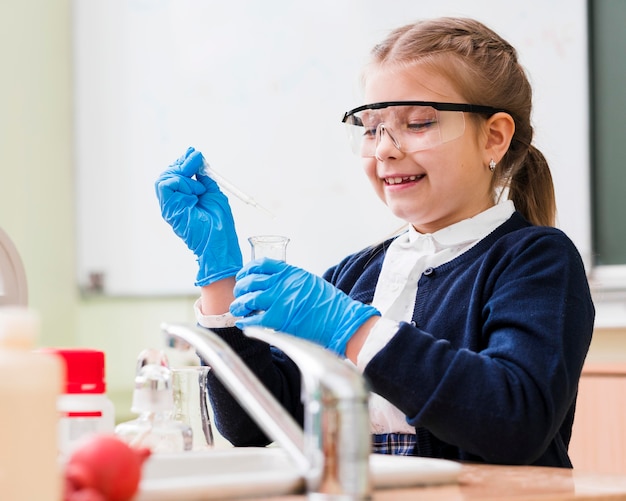 Niña sonriente estudiando química