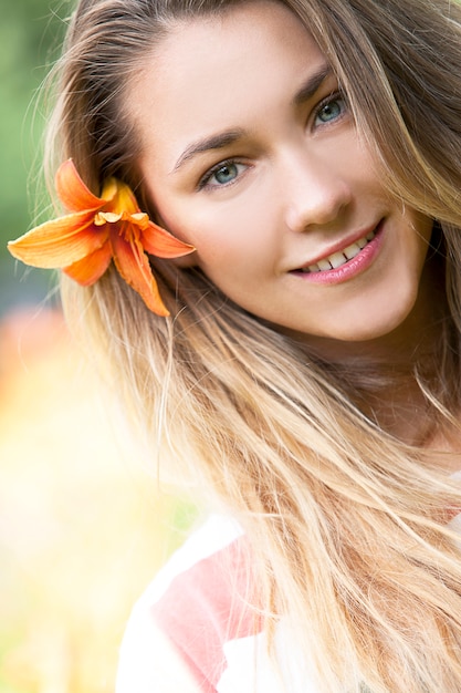 Niña sonriente con flor de lirio en el pelo