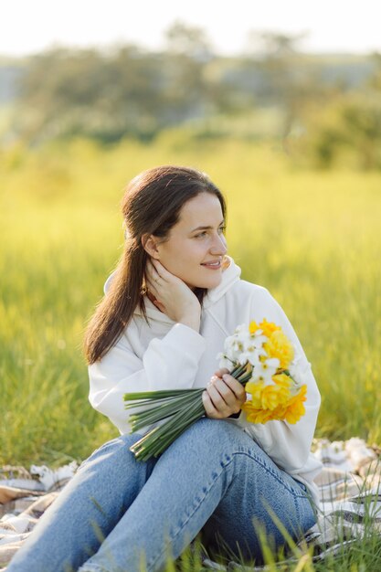 Niña sonriente con flores caminando por el bosque